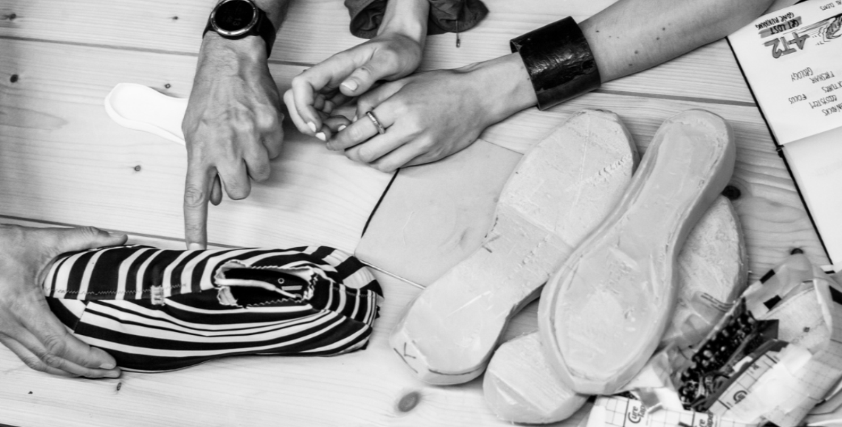 Close-up of a shoe insole with a striped pouch on a wooden surface.